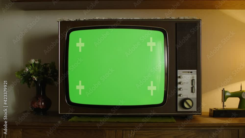 Old Retro Wooden TV in a vintage ambient with a green screen on it.