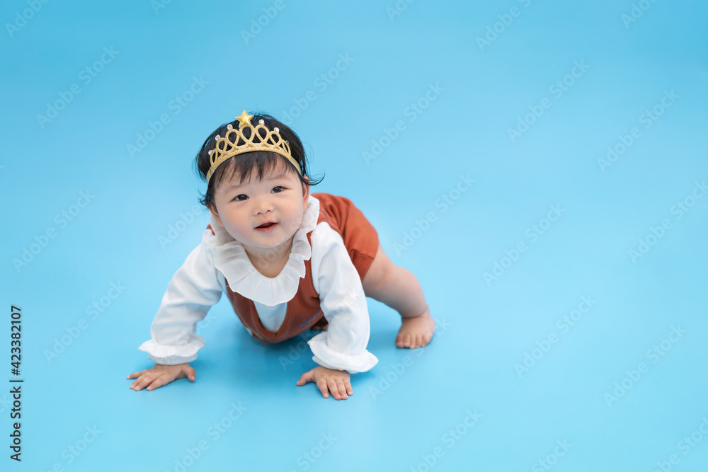 Asian happy baby smiling and crawling on blue background. Cute 6 months baby with copy space use as concept of bedroom, drypers, development, baby or kid department in hospital. Asian happy baby smiling and crawling on blue background. Cute 6 months baby with copy space use as concept of bedroom, drypers, development, baby or kid department in hospital.