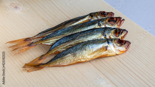 Horse mackerel fish, cold smoked. Smoked fish close-up on a wooden background .Food industry photo