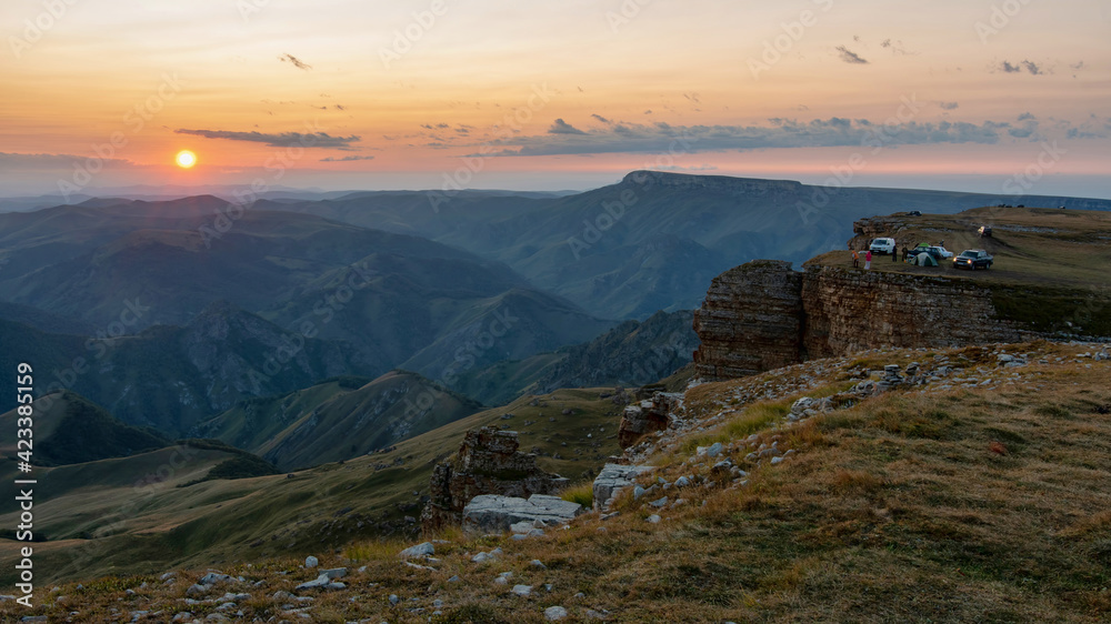 Sunset Caucasian landscape. View of camp on the cliff edge of Bermamyt plateau. Karachay-Cherkessia, Caucasus, Russia.