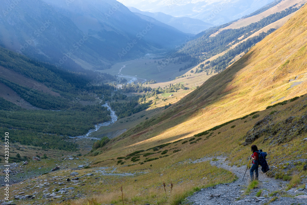 A hiker (girl) climb up Sophia Sedlo pass in Sophia river valley (Arkhyz region). Karachay-Cherkessia, Caucasus, Russia.