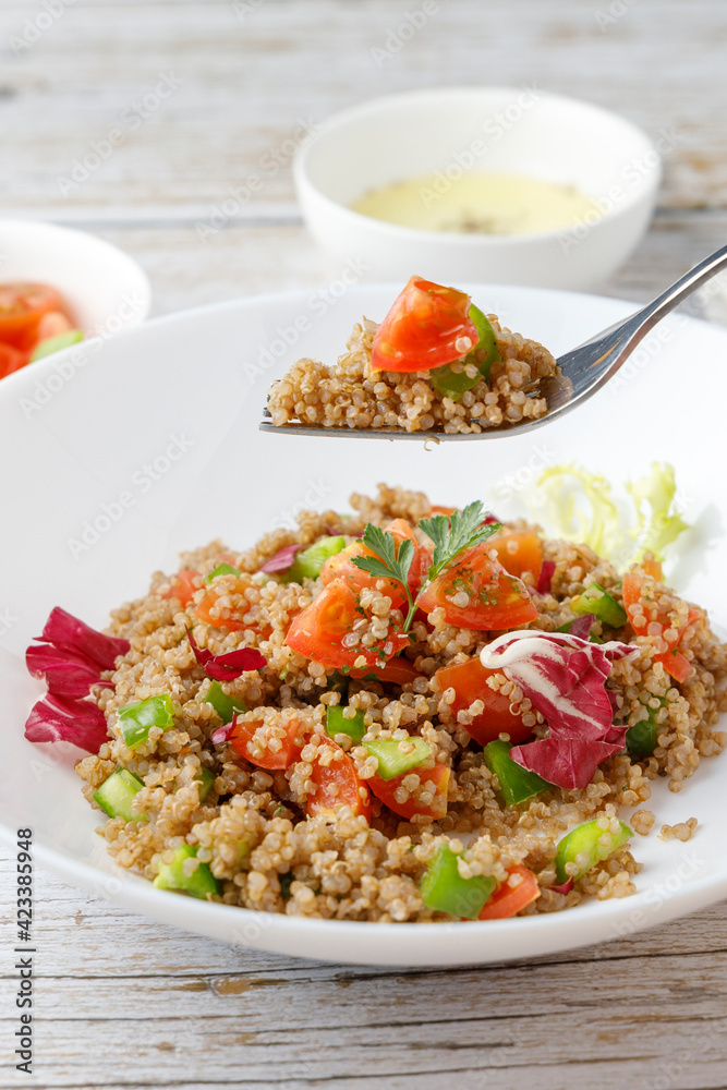 Healthy rustic quinoa salad with vegetables on a white wood table Healthy rustic quinoa salad with vegetables on a white wood table