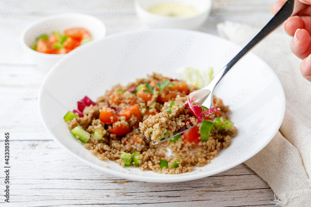 Healthy rustic quinoa salad with vegetables on a white wood table Healthy rustic quinoa salad with vegetables on a white wood table