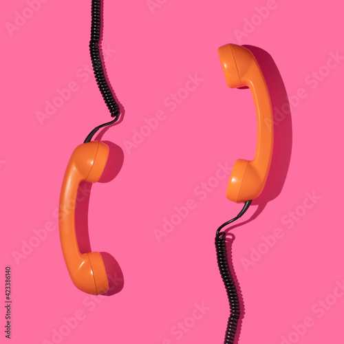 Creative layout with couple old phone handsets on bright pink background. Retro fashion style. Minimal aesthetic telephone call concept. Spring or summer idea. photo