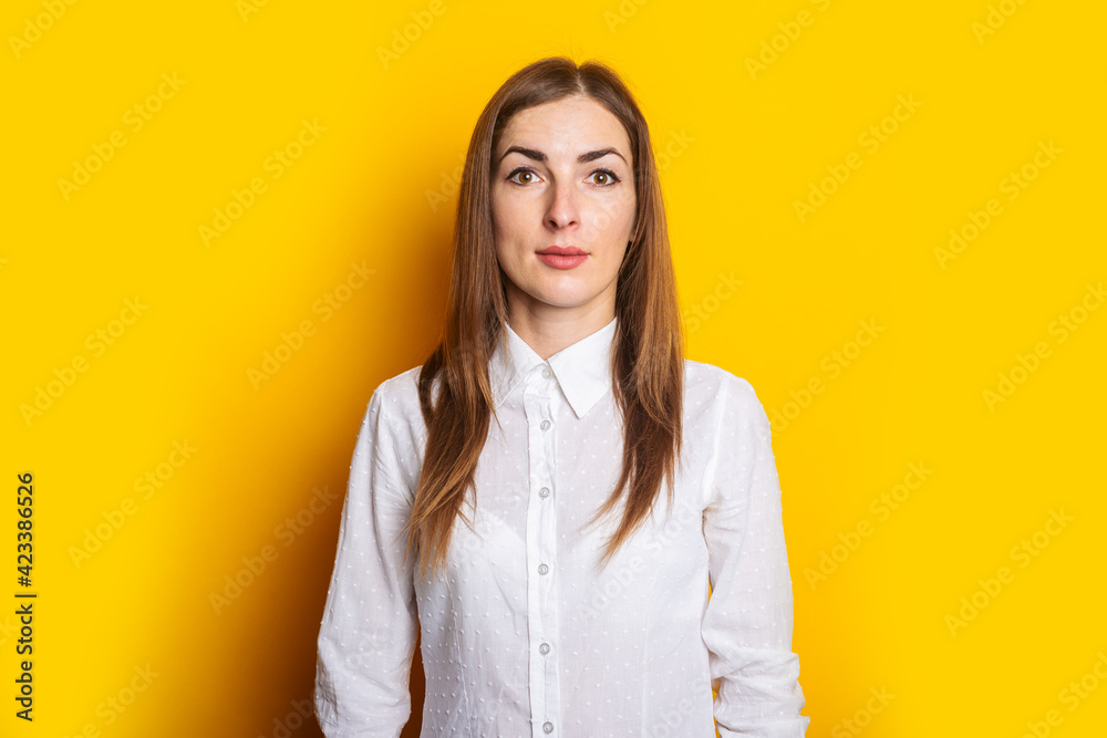 Young woman in a white shirt on a yellow background. Businesswoman concept Young woman in a white shirt on a yellow background. Businesswoman concept