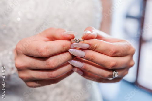 Gold ring with a stone in the hands of the bride