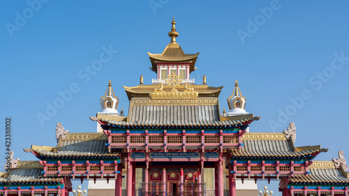 View of Golden Temple of Buddha Shakyamuni and the main gates against blue sky. Elista  Kalmykia  Russia. Inscription on the gates means    Golden Temple of Buddha Shakyamuni   .