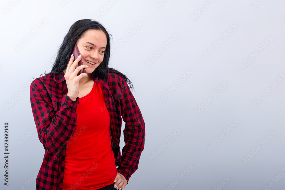 dark-haired emotional young woman in a red clothes talk on mobile phone, isolated, copy space dark-haired emotional young woman in a red clothes talk on mobile phone, isolated, copy space