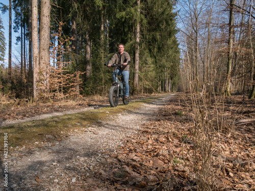 Young man rides modern E-bike through the forest © Peter Maszlen