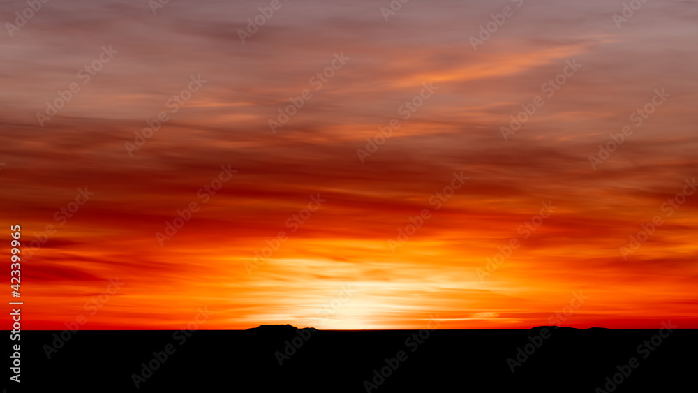 Luminous sunset in bright orange and red with black silhouette coastline.Shot in Sweden, Scandinavia