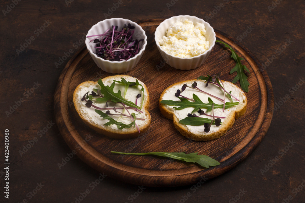Two sandwiches with amaranth microgreens - purple leaves and stems and fresh rucola leaves. Vegan and healthy food concept.