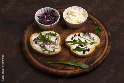 Two sandwiches with amaranth microgreens - purple leaves and stems and fresh rucola leaves. Vegan and healthy food concept.