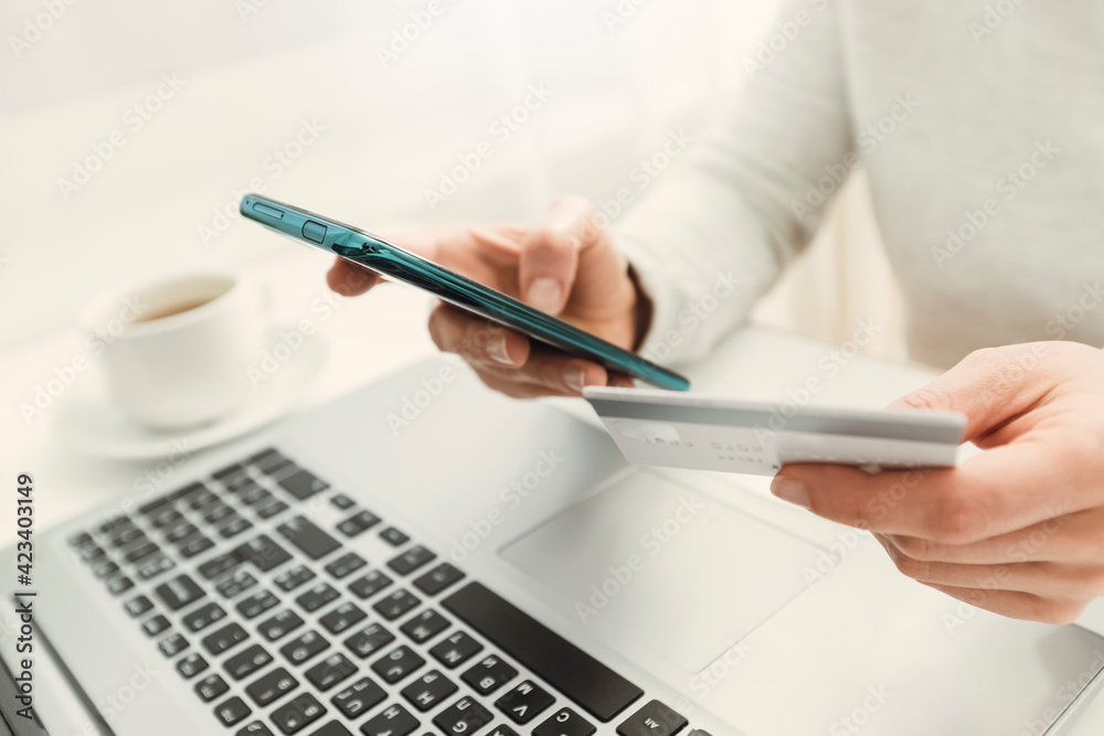 E-commerce via laptop. Using a phone and a credit card to buy and pay in an online store. Shopping remotely on a smartphone. E-commerce via laptop. Using a phone and a credit card to buy and pay in an online store. Shopping remotely on a smartphone.