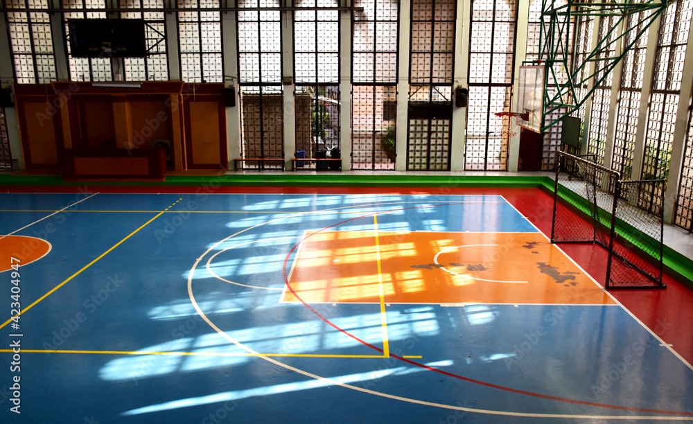 Basketball court, school gym indoor has sunlight shining in the morning