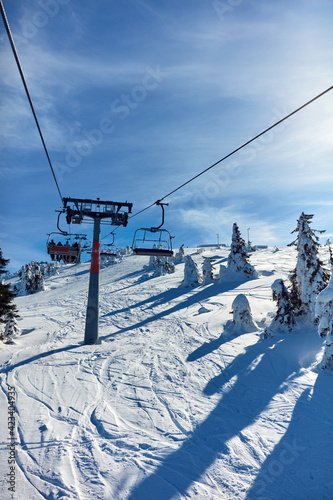 Empty ski chair lift on a mountain - season with no tourists. © astrosystem