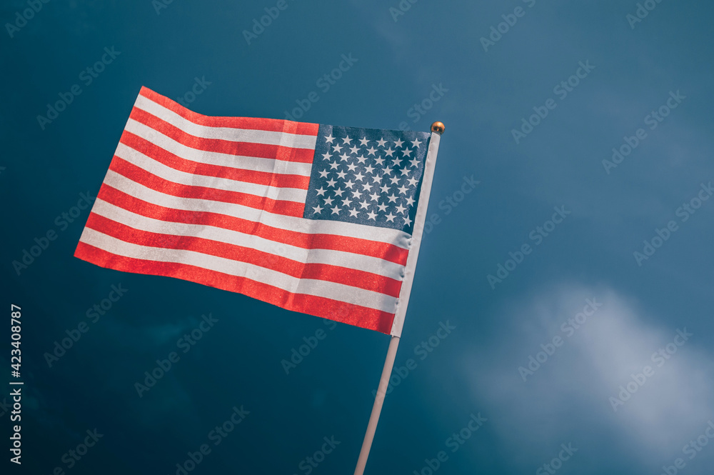 Obraz premium American flag, on against a overcast sky.