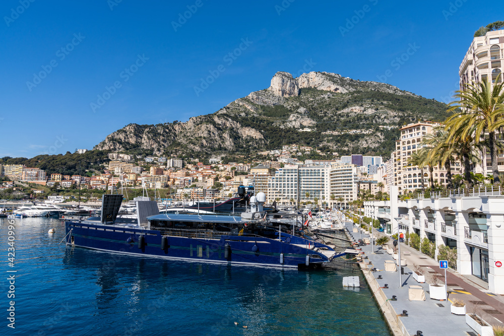 luxury yachts in the harbor of Cap d'Ail and Monaco cityscape in the background