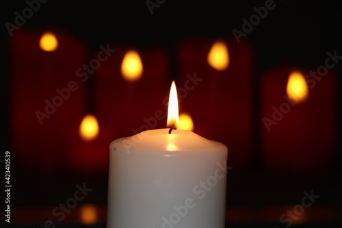 Red electronic candles and white candles isolated on a black background