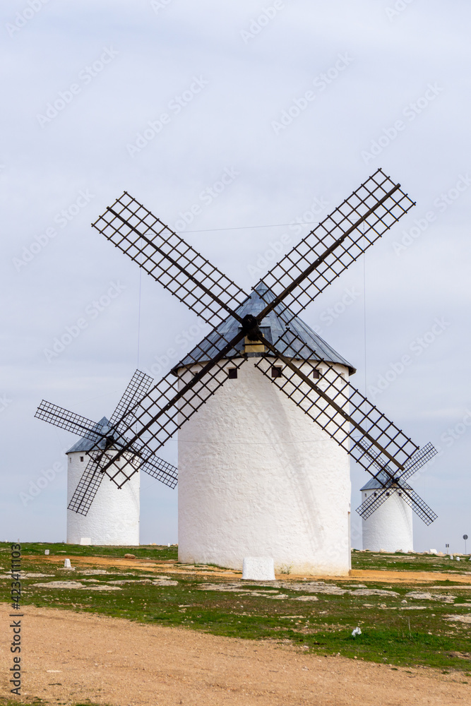 three whitewashed traditional Spanish windmills on the plains of La Mancha