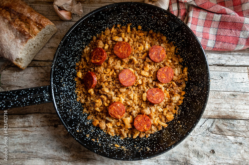 Migas Manchegas, a traditional dish from Castilla la Mancha in Spain, on a rustic wooden background.  photo