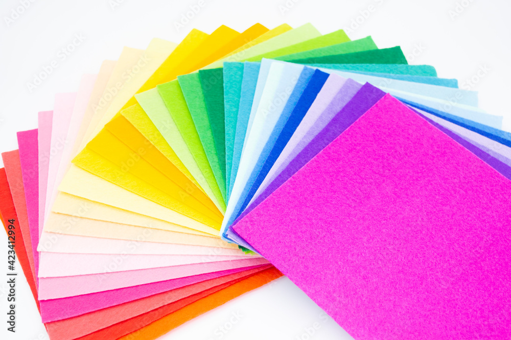 The square pieces of felt spread out by a color spectrum on similarity of a rainbow: from shades of red, pink, yellow, green, blue and bright violette at the end