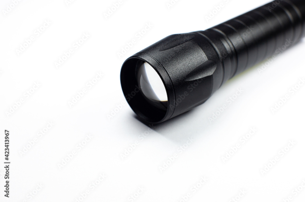 Black Flashlight on the white background. Close up. Black Flashlight on the white background. Close up.