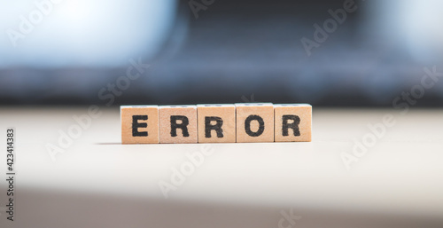 Error or bug concept: Wooden cubes with letters “Error” lying on a laptop, concept for computer crash