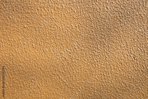 Light brown concrete wall texture for background usage with shadow. Orange rough backdrop. Stucco surface. Abstract pattern. Texture of paint on grooved plaster. Abstract art creative background.