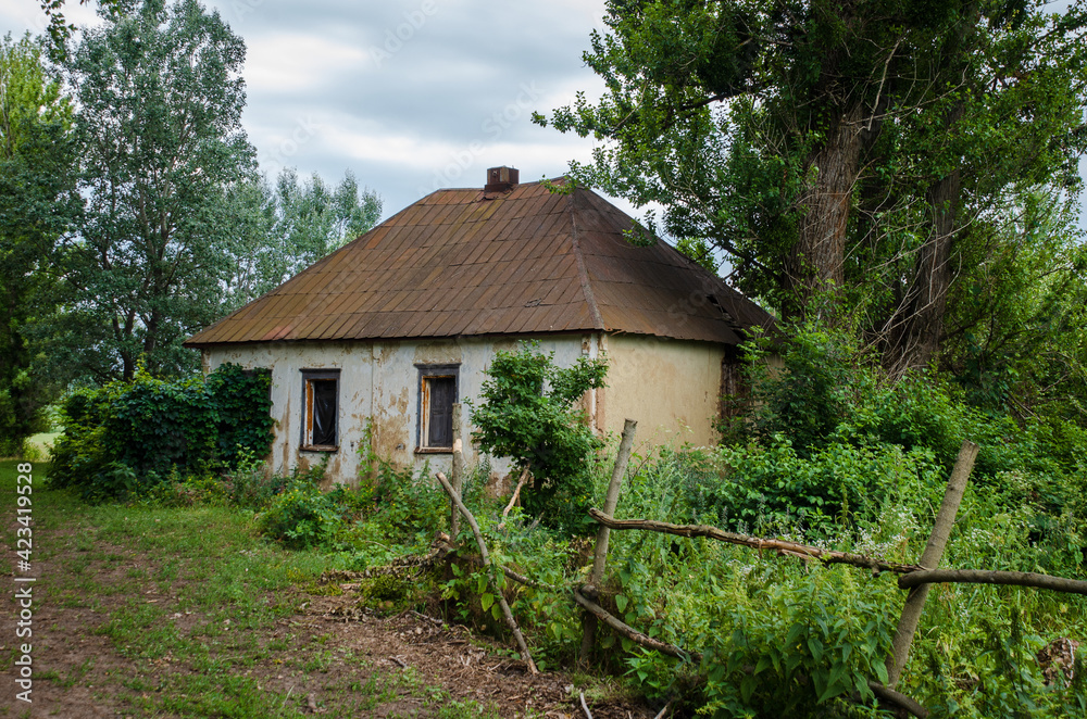 Old house on the outskirts of the village with an iron roof