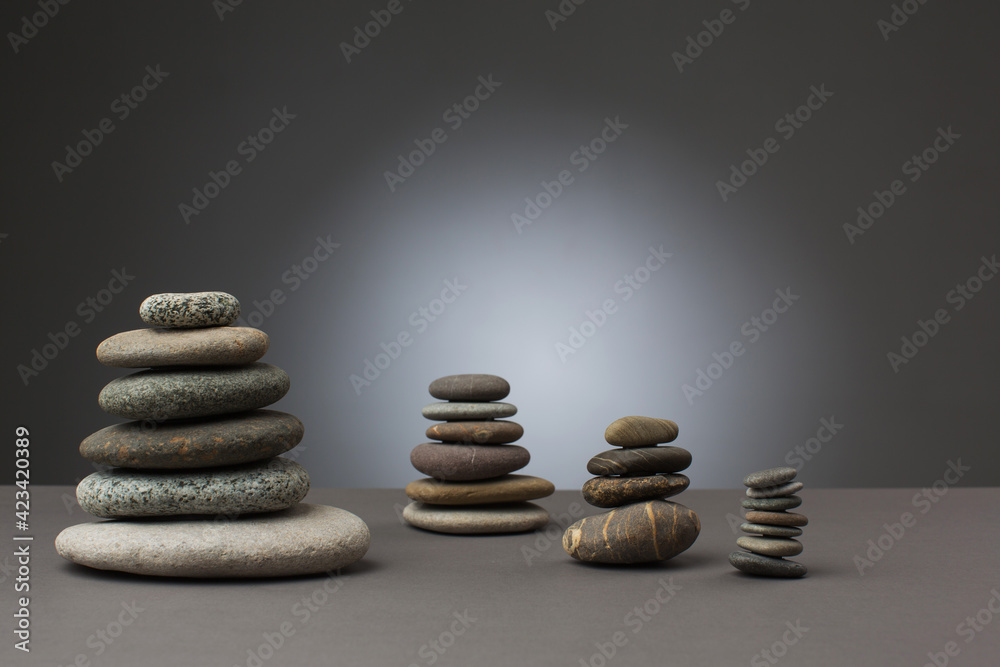 Fototapeta premium Stones standing in balance on grey background