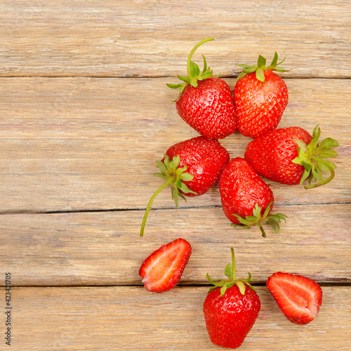 pattern of ripe strawberries on a wooden table. Top view.