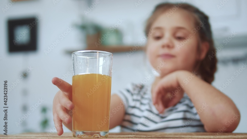 little girl child drinking juice. healthy eating a child eating breakfast kid dream concept. daughter girl in kitchen drinks juice and licks her orange lips. positive kid smiling having breakfast little girl child drinking juice. healthy eating a child eating breakfast kid dream concept. daughter girl in kitchen drinks juice and licks her orange lips. positive kid smiling having breakfast