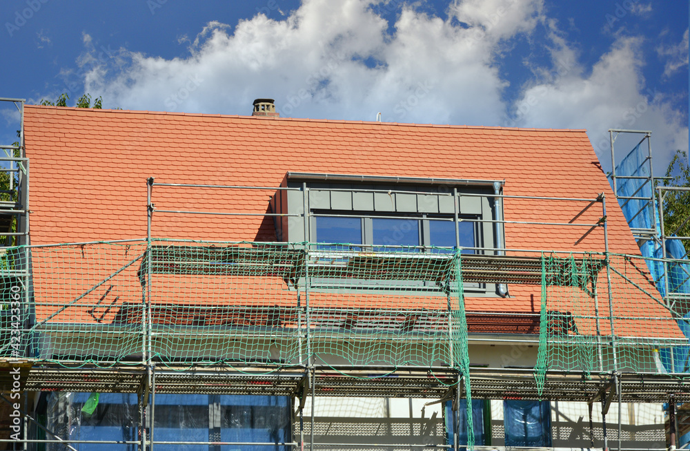 Gerüst an einem neu gebauten Mehrfamilien-Wohnhaus im Rohbau in einem Neubaugebiet Gerüst an einem neu gebauten Mehrfamilien-Wohnhaus im Rohbau in einem Neubaugebiet