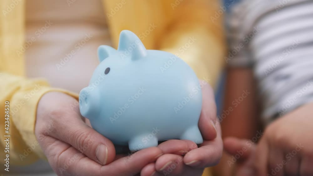 happy family piggy bank. mom and daughter a put coins in the piggy bank
