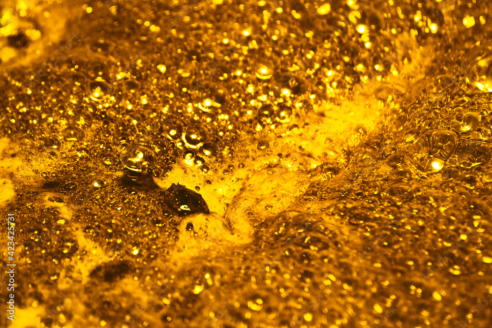 Boiling gold. Foam texture as background. Background and texture concept. Close up of bubbling golden foam
