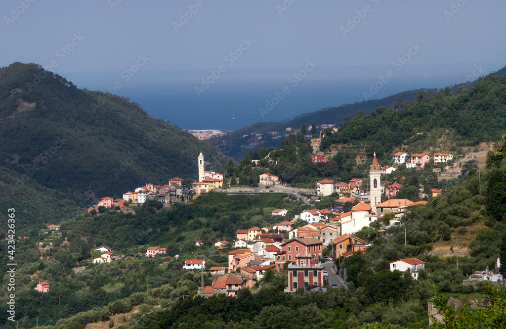 Wonderful view of the Italian village in the mountains. Against the background of the sea in the haze.