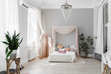 Minimalist scandinavian bedroom with tester bed and baldachin and pale pink folding-screen