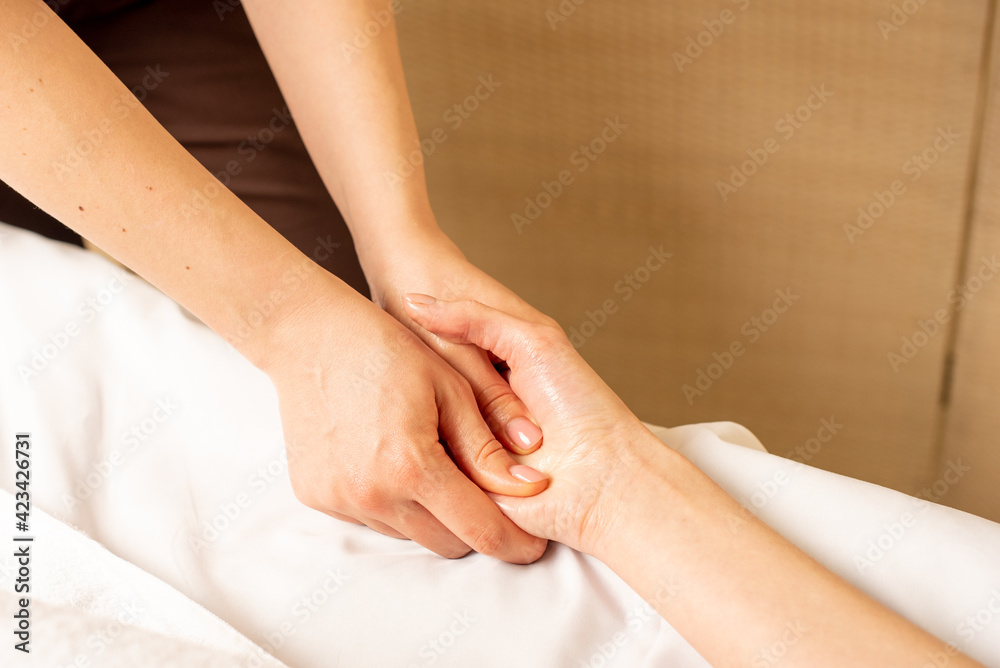 Hand massage. Physiotherapist pressing specific spots on female palm. Professional health and wellness acupressure manipulations Hand massage. Physiotherapist pressing specific spots on female palm. Professional health and wellness acupressure manipulations