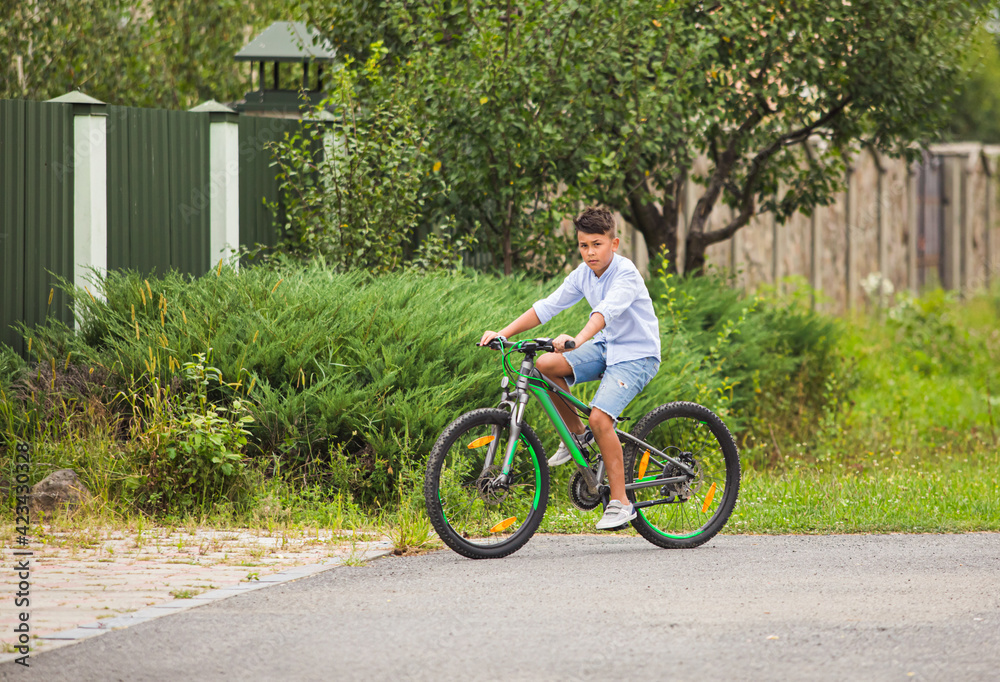 Teenage boy is riding on a bicycle