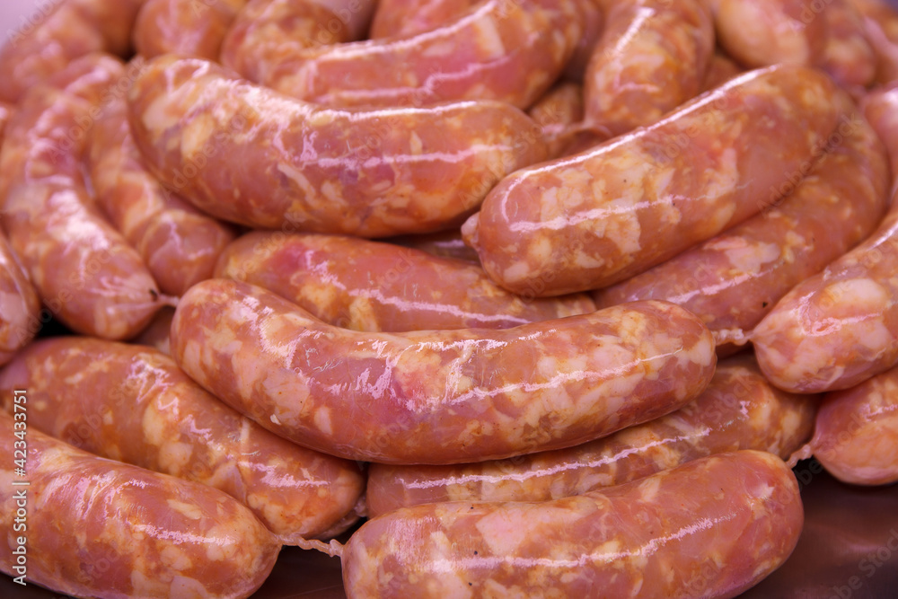 Raw delicious farm chicken sausages close up for grilling Raw delicious farm chicken sausages close up for grilling