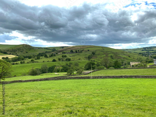 Landscape view from  Standsfield Brow  with fields  distant meadows  and hills  on a cloudy day in  Lothersdale  Keighley  UK