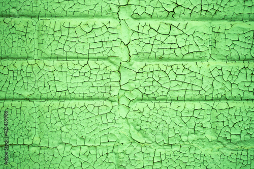background or texture green crackly paint on brick structure closeup