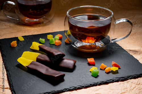 pieces of passion fruit in chocolate on the background of a cup of tea