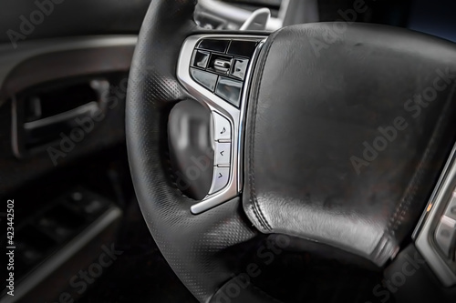 Multifunctional leather steering wheel in black in a modern car.