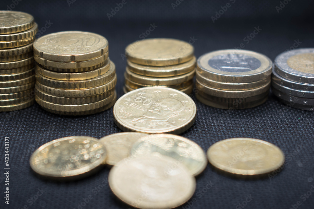 Euro Coins stacks on black background in different positions.Euro coins stacked in different combinations Euro Coins stacks on black background in different positions.Euro coins stacked in different combinations