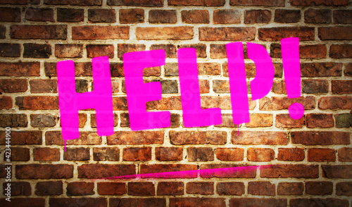 Help sign spray painted on the brick wall