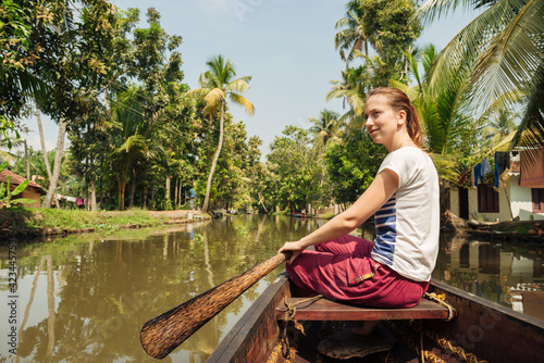 Tourist woman boating on Alleppey backwaters and enjoyin beautiful view