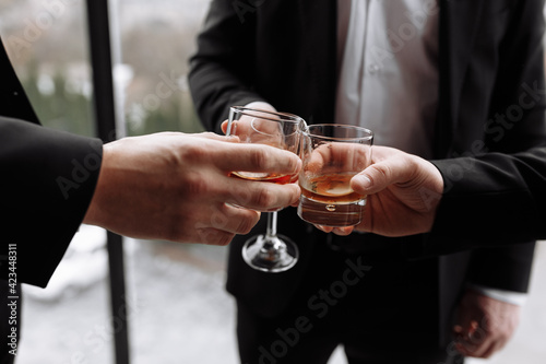 Business meeting. Men hold glasses of whiskey. Men's Party. Hand with a drink of alcohol