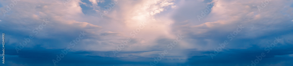 Panoramic sky with yellow sun and Stratocumulus clouds. A panorama of the cold blue sunset sky.