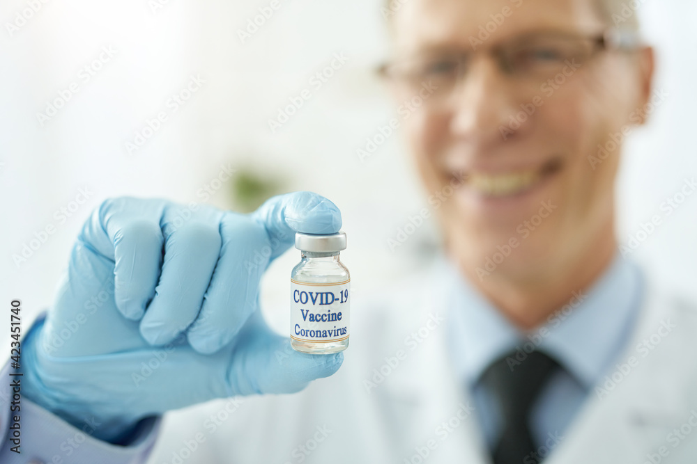 Male doctor hand in sterile glove holding covid-19 vaccine Male doctor hand in sterile glove holding covid-19 vaccine